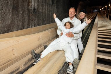 Rutschen Kind Mann Guide | © Bergauer Salzwelten Hallstatt Rutsche mit Kind und Vater mit Tourguide | © Bergauer