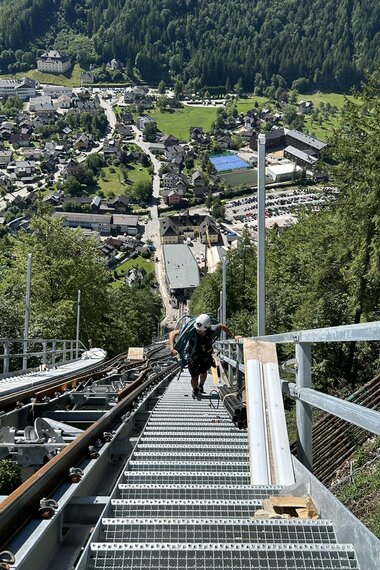 Salzwelten Hallstatt Umbau Salzbergbahn Stiegen neben Strecke Person geht hinauf    | © Salzwelten