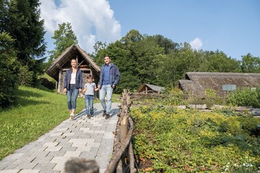 Familie im Keltendorf beim Kräutergarten | © Bergauer Freilichtmuseum Holzhütten Kräuter Kelten | © Bergauer