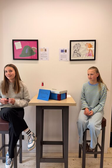 Salzwelten Altaussee Ausstellung Steinberghaus erster stock Schülerinnen sitzend auf Hocker mit Kunstwerte im Hintergrund  | © ©Salzwelten Grögler 